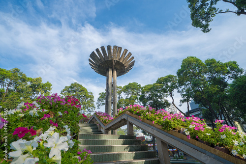 Canvas Print Wide angle view of Lotus pillar - An iconic architecture at Turtle lake (Ho Con Rua) with blue sky in Saigon