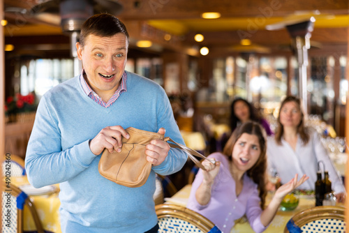 Insidious adult man trying to snatch handbag of young woman visiting restaurant for lunch..
