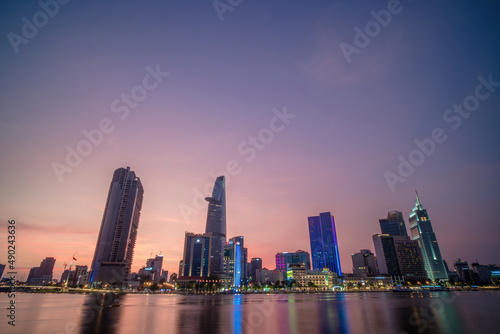 View of Bitexco Financial Tower building, buildings, roads, Thu Thiem bridge and Saigon river in Ho Chi Minh city in sunset. High quality panorama image. photo