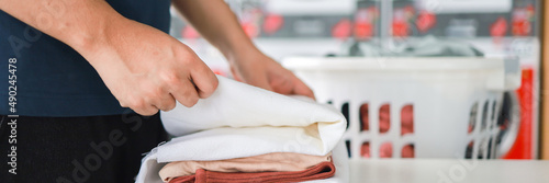 House husband with Basket and dirty laundry washed clothing in laundry room interior. washing machine at laundry business store