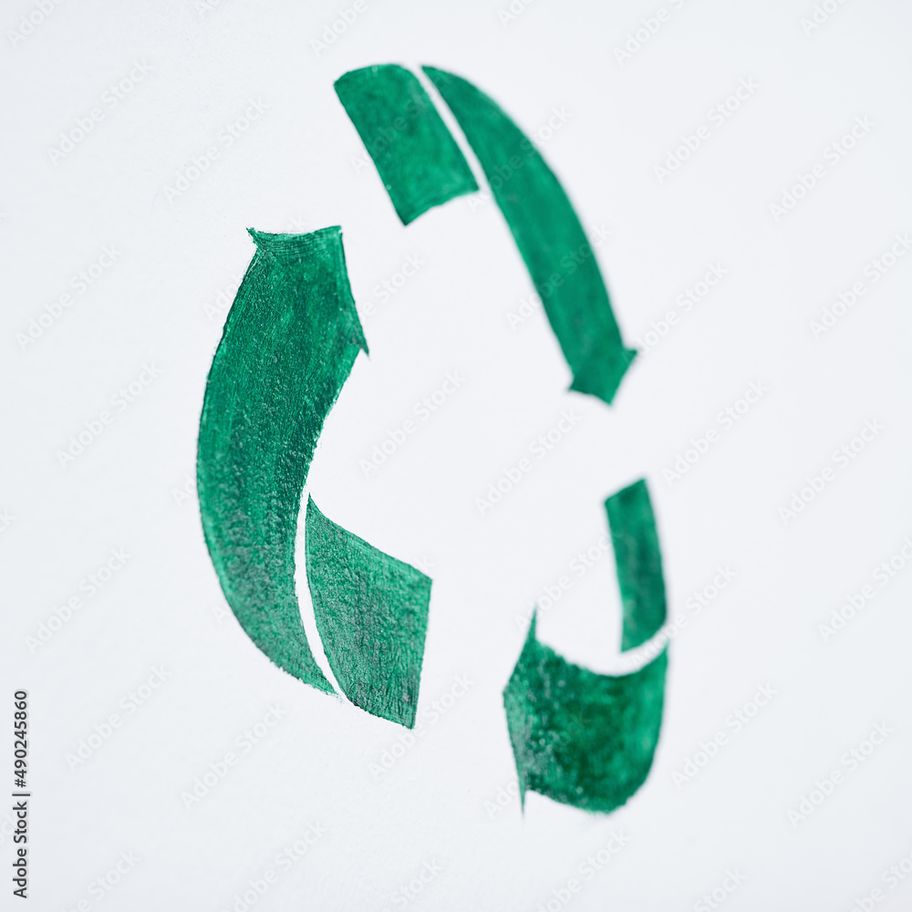 Obraz premium The way to tomorrow starts with a cleaner today. Shot of a green recycle symbol painted on a wall.