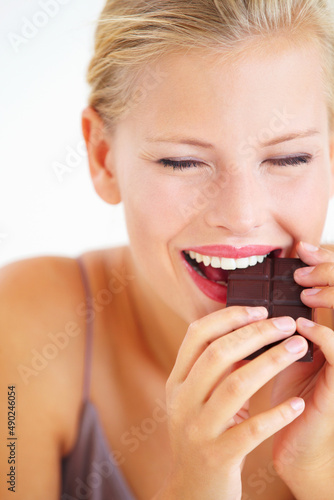 Ah  this is amazing. Young woman enjoying a delicious piece of chocolate with delight.