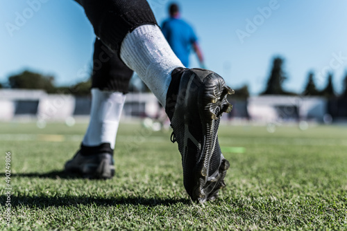 man entering the soccer field with boots