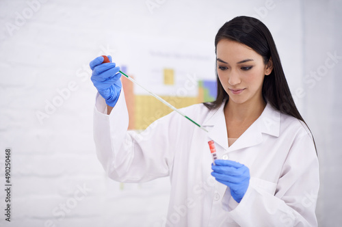Perfection is important. Shot of a female scientist using a dropper on a test tube.