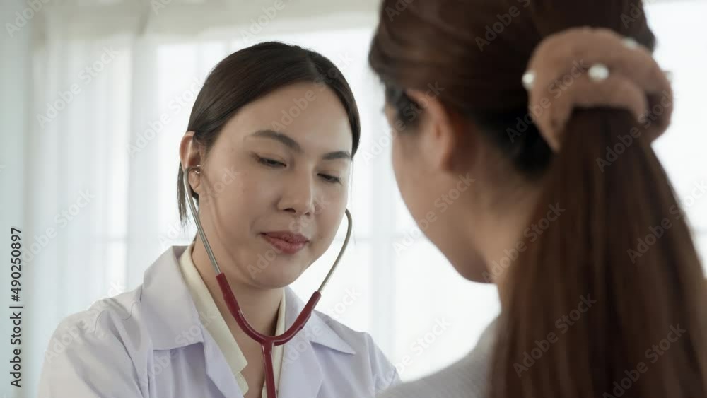 4K 50fps, Asian female doctor applying a stethoscope to patient's chest Listen to the heart to know the patient's symptoms. 4K 50fps, Asian female doctor applying a stethoscope to patient's chest Listen to the heart to know the patient's symptoms.