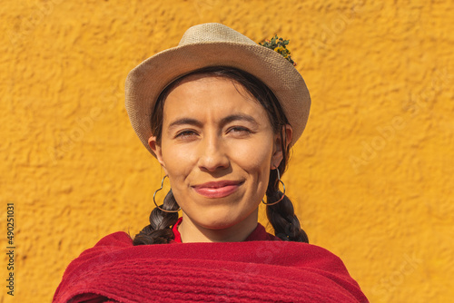 Close-up of the face of a latin indigenous woman with a hat and red shawl