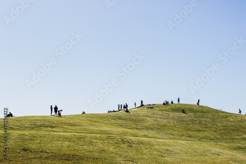 silhouettes of many people on hill at Gasworks park in Seattle lounging, picnicking, sitting on grass photo