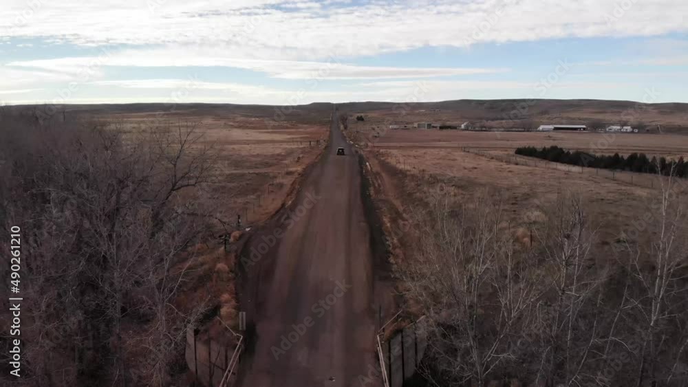 Dirt Road in Countryside on a Cloudy Day with Trees by Bridge • Aerial Drone Shot Dirt Road in Countryside on a Cloudy Day with Trees by Bridge • Aerial Drone Shot