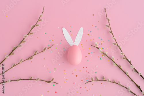 Fototapeta Naklejka Na Ścianę i Meble -  Easter bunny egg, confetti, pussy willow on a pink background.  Easter banner with space for text