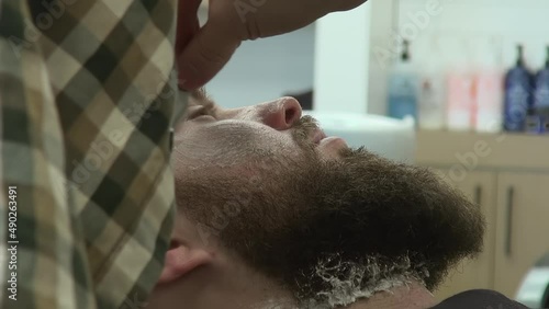 Shavette cutthroat straight razor used to shape customer's hair, beard photo