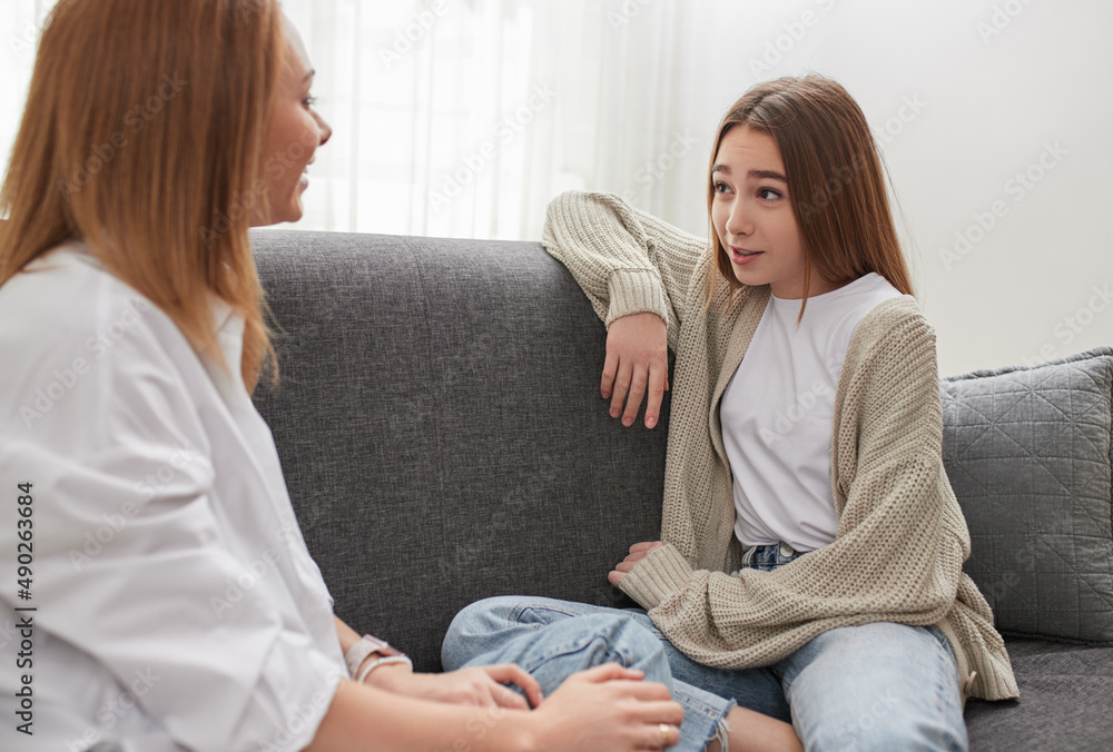 Mother and daughter talking to each other at home Mother and daughter talking to each other at home