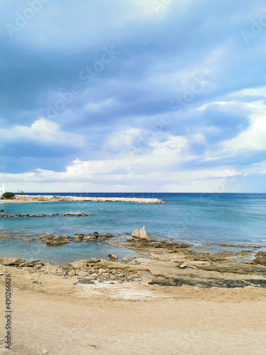 Rocky shore with sand  sandy beach  the temple of St. Nicholas the Wonderworker against the backdrop of a dramatic sky.