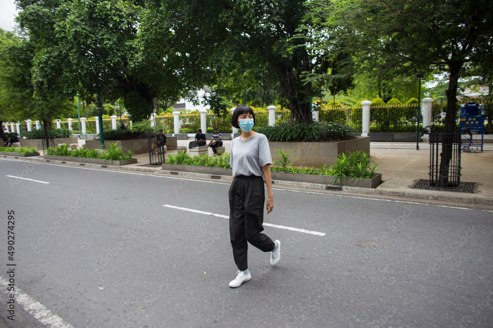 Asian Woman with medical mask crossing the road
Asian Woman with medical mask crossing the road
