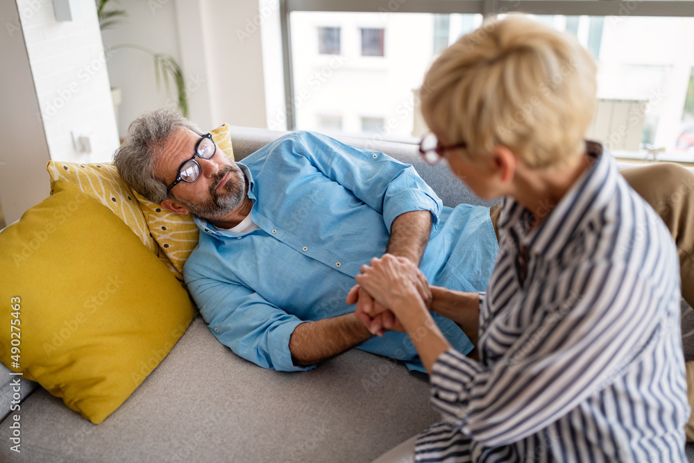 Fototapeta premium Senior woman comforting man with depression, health problem, stress at home