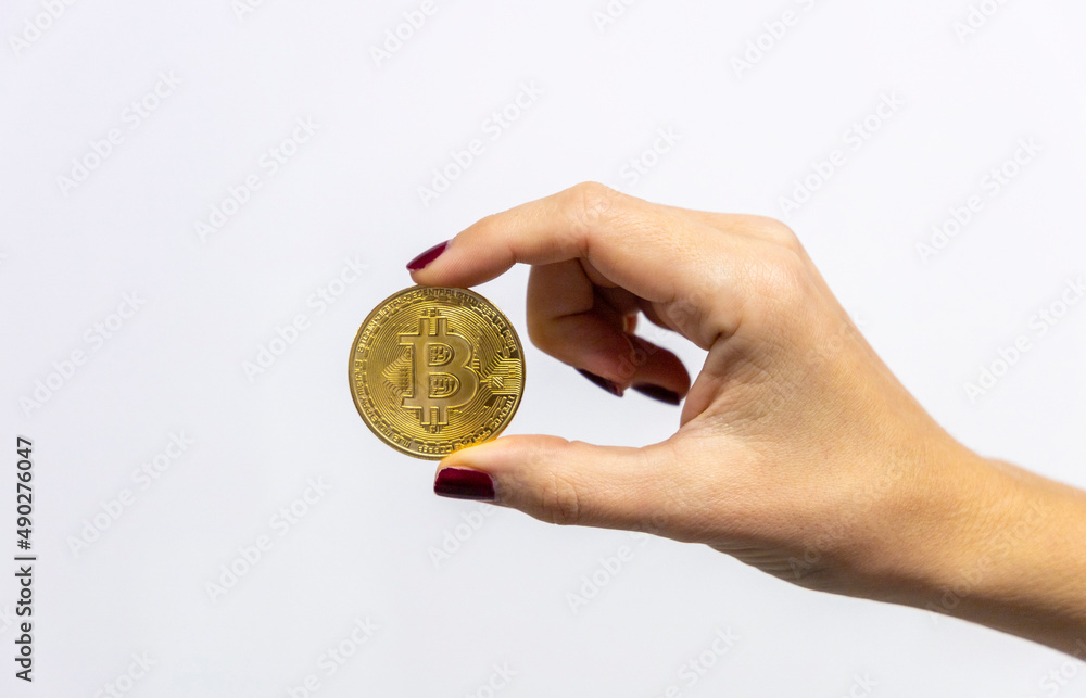 Fototapeta premium A bitcoin coin in a woman's hand