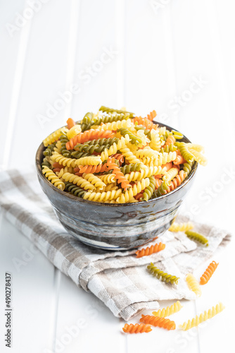 Three colors fusilli pasta. Colorful italian raw pasta in bowl.