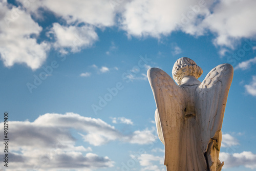 Une statue d'un ange de dos face au ciel. Un ange priant pour le paradis. Une icone religieuse. Le symbole de la mort. photo