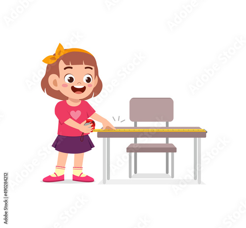 girl holding measure tape and check length of table