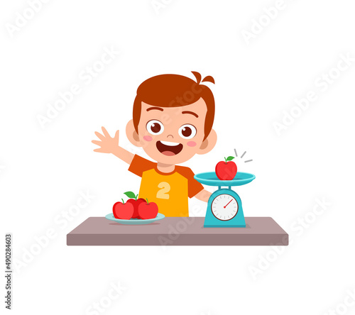 little boy measure weight of fruit using weighing scale
