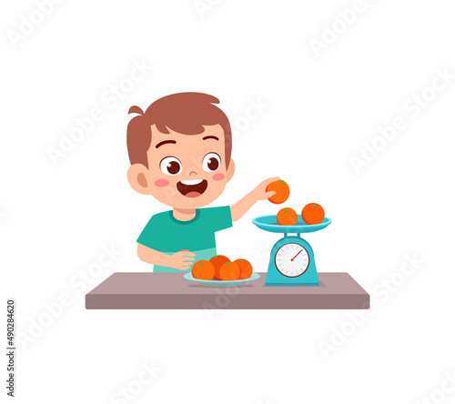 little boy measure weight of fruit using weighing scale