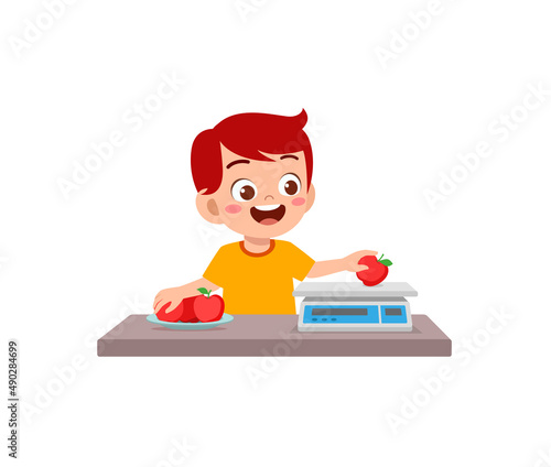 little boy measure weight of fruit using weighing scale