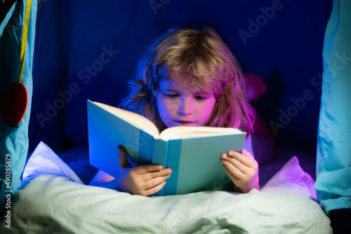 Child boy reading book. Close up portrait of kids reading story. Dreaming child read bedtime stories, fairystory or fairytale.