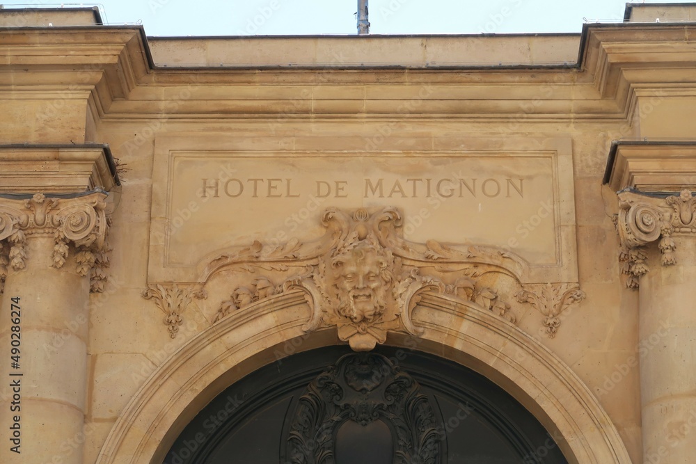 Inscription "Hôtel de Matignon" au dessus de la porte d'entrée du palais de résidence officielle du Premier Ministre français, rue de Varenne à Paris, avec un mascaron (France) - obrazy, fototapety, plakaty 