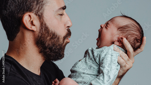 father with expression of feeling looks at his son who is screaming in front of him