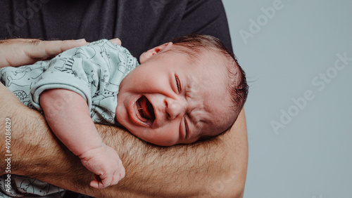 Fotografie, Tablou newborn on his father's arm screams crying with expression of suffering