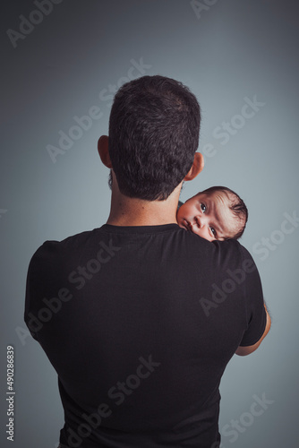 Father Holds Newborn Son in Study Shot