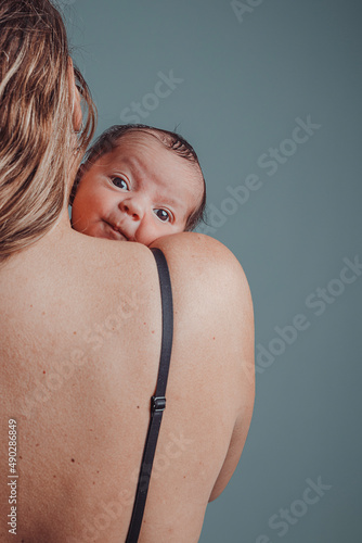 Mother holds her newborn son with surprised expression