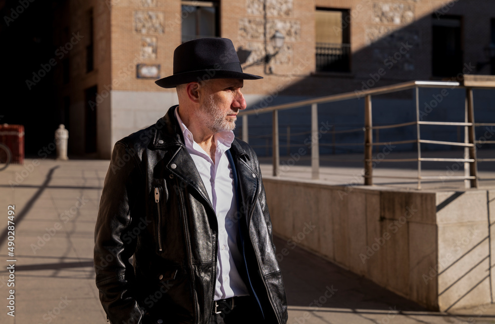 Portrait of adult man in hat and leather jacket on street. Madrid, Spain