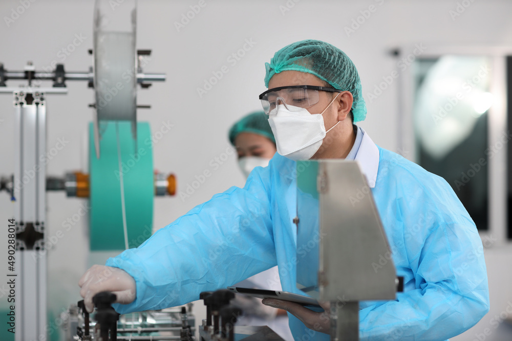 Inspector man and colleague woman working on quality of mask and medical face mask production line, Industry and factory concept. Inspector man and colleague woman working on quality of mask and medical face mask production line, Industry and factory concept.