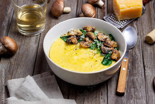 Polenta with mushrooms, spinach and cheese. Healthy eating. Vegetarian food. Italian cuisine.