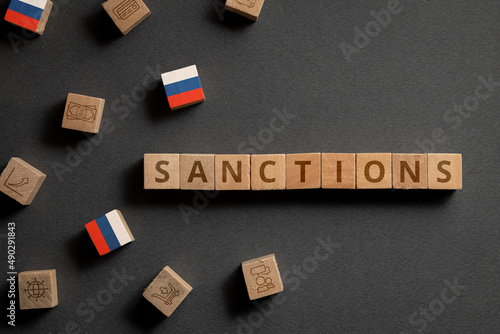Wooden cubes with financial icons, Russian flag and sanctions. Concept on sanctions in Russia photo