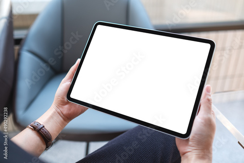 Wallpaper Mural Mockup image of a woman holding digital tablet with blank white desktop screen in cafe Torontodigital.ca