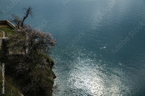 high angle view on sun reflection on the water surface near a cliff at lake ohrid