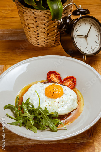 breakfast fried eggs with beefsteak, arugula and sun-dried tomato
