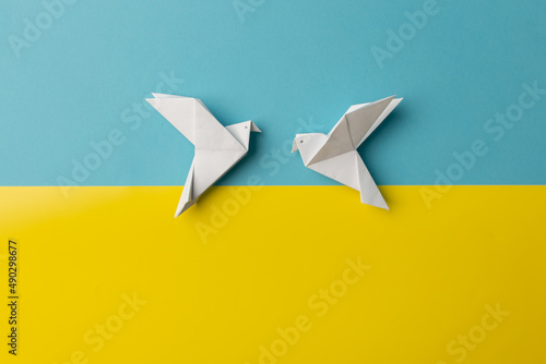 Two white birds as a symbol of peace on on blue and yellow pastel paper color for background