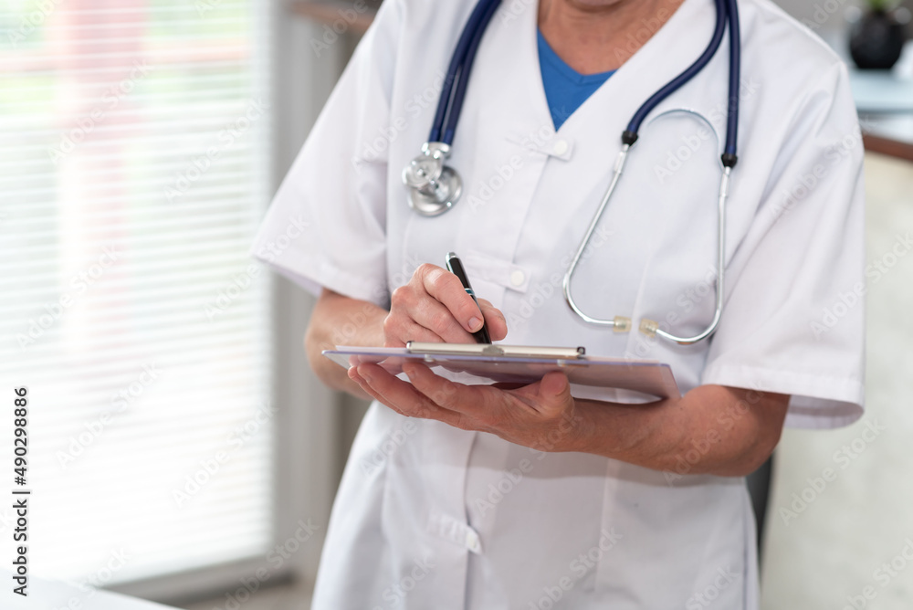 Female doctor taking notes on clipboard Female doctor taking notes on clipboard