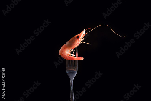shrimp stabbed on a fork on a black background