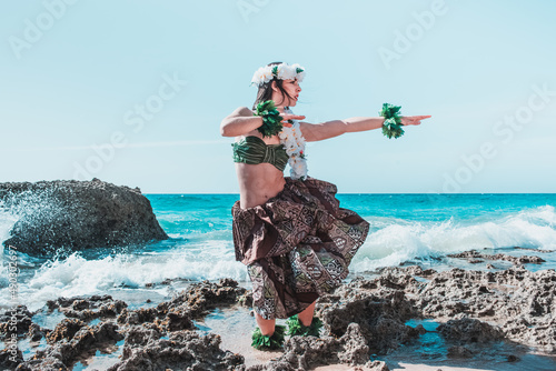 Hawaiian woman enjoys hula dancing on the beach barefoot wearing traditional costume. Hula dancer lady dancing Hawai dance. photo