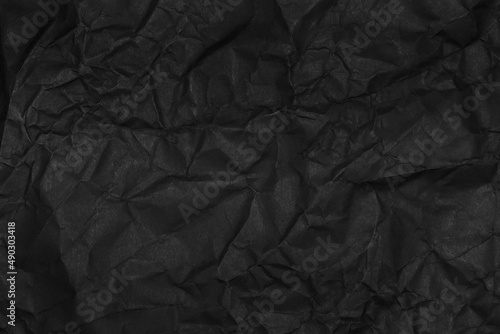 black crumpled paper texture as background © treerasak