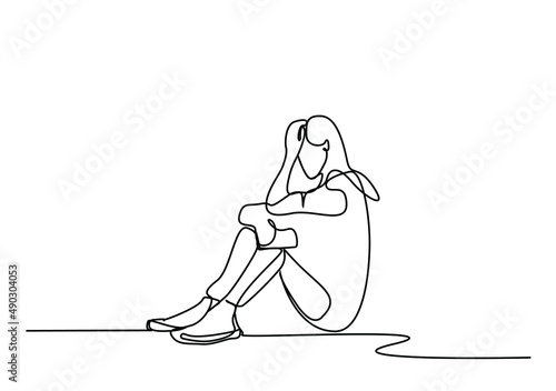 woman holding phone in hand, receiving bad news, sitting on the floor sadly