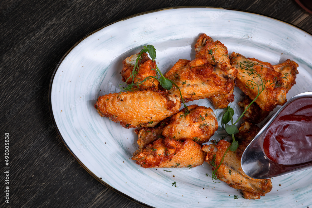 fried chicken wings served with beer on a dark background fried chicken wings served with beer on a dark background
