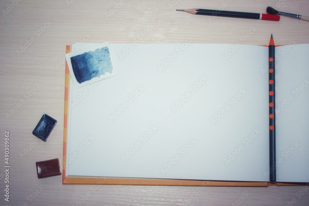 Spread album with white paper, with pencils, paints, mockup for illustration Spread album with white paper, with pencils, paints, mockup for illustration