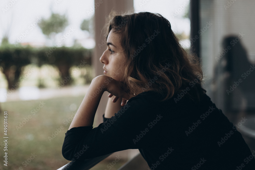 Calm pretty teenager girl on the balcony looking away Calm pretty teenager girl on the balcony looking away
