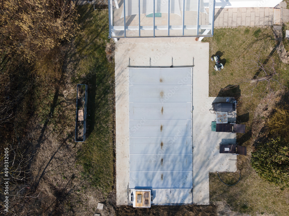 Drone flight over a covered pool with a tarp that is still under construction in a garden Drone flight over a covered pool with a tarp that is still under construction in a garden