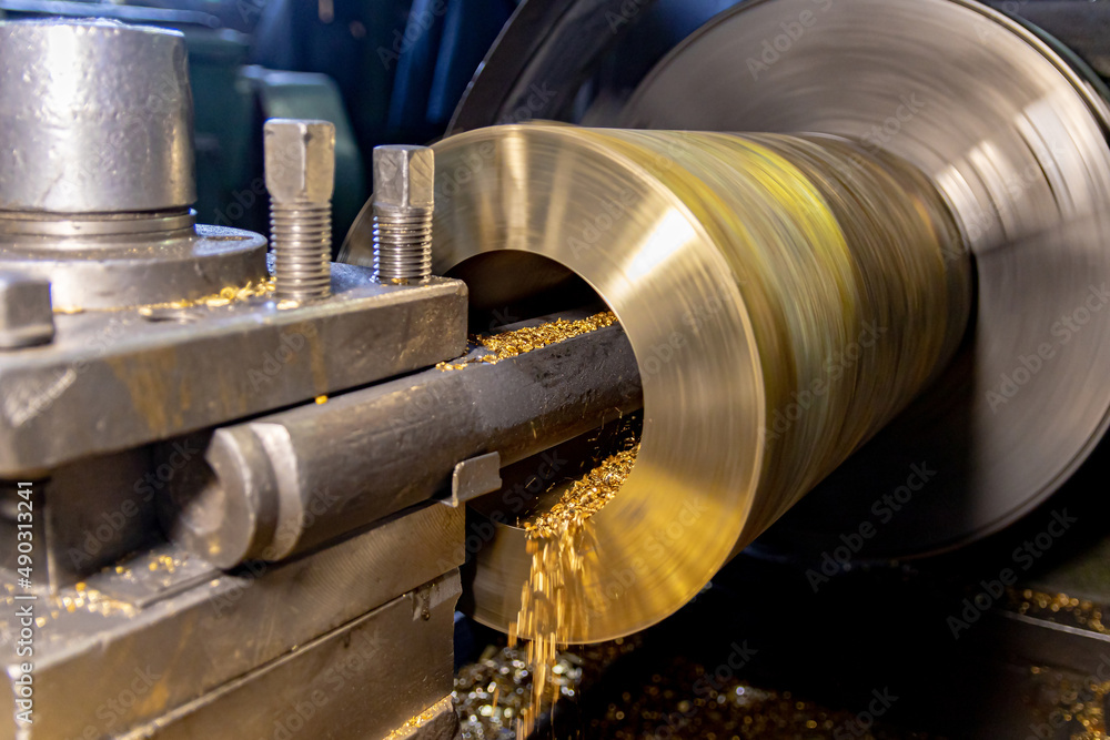 The work of a lathe in the production of non-ferrous metal products. Soft focus The work of a lathe in the production of non-ferrous metal products. Soft focus