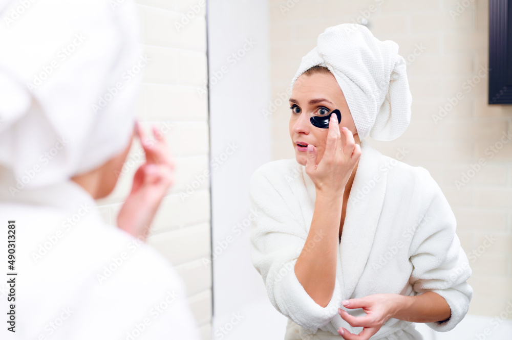 Obraz premium Beautiful caucasian young woman with under-eye patches in bathroom